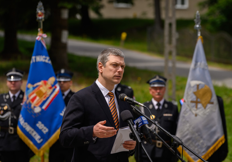 Karol Madaj przemawia w tle ochotnicza straż pożarna ze sztandarami 