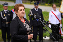 Kobieta przemawia do mikrofonu.