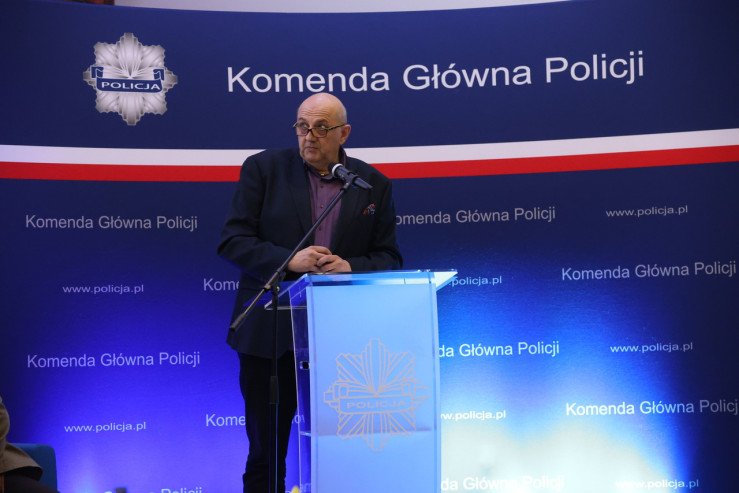 Mężczyzna przy pulpicie przemawia podczas konferencji. 